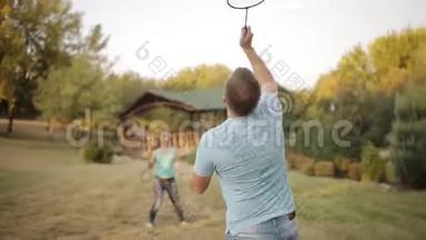 夫妇在公园打羽毛球，笑。